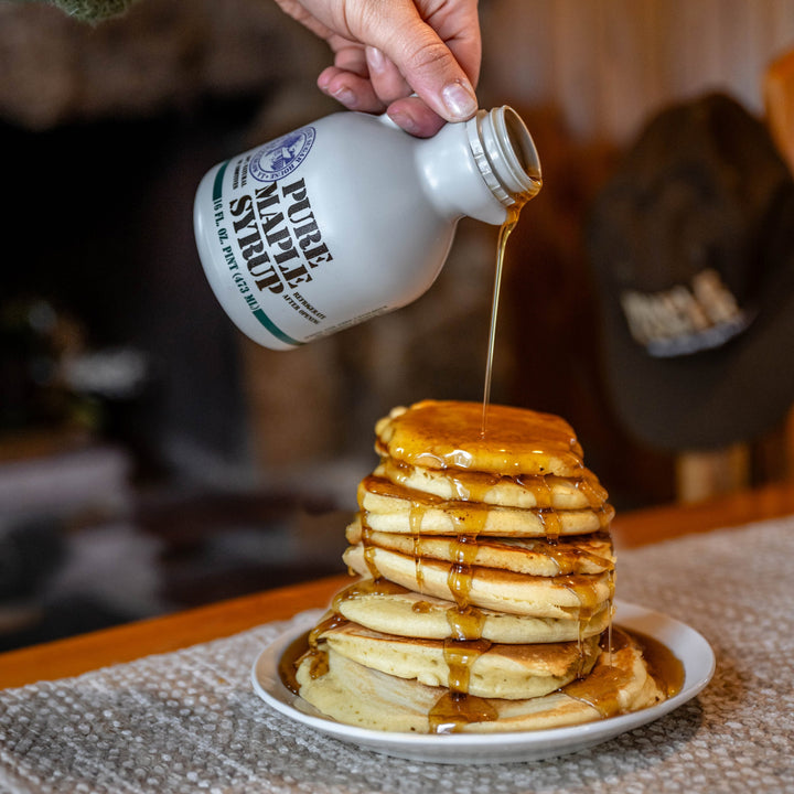 Pouring a pint of Green Mountain Sugar House maple syrup over a stack of pancakes